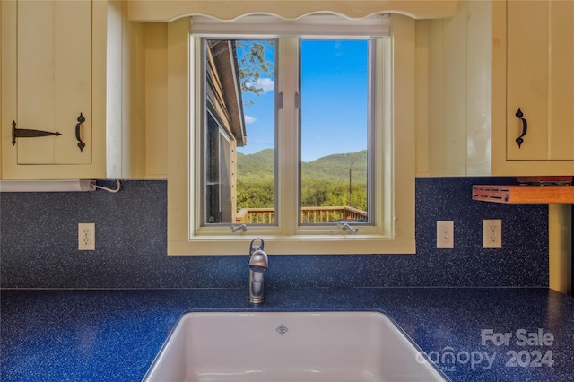 kitchen with a mountain view, sink, and decorative backsplash