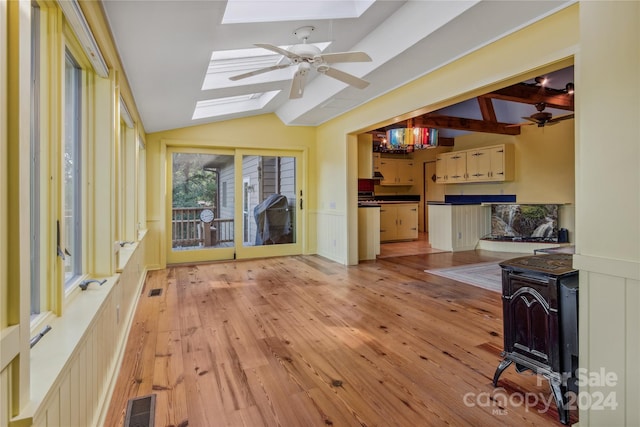 living room with light wood-type flooring, ceiling fan, and lofted ceiling with skylight