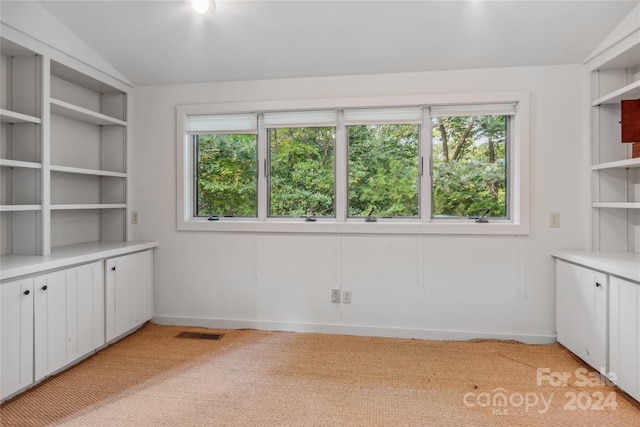 interior space with lofted ceiling and light colored carpet