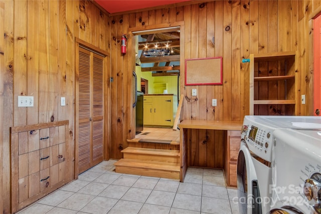 interior space with washing machine and dryer, wooden walls, and tile patterned floors