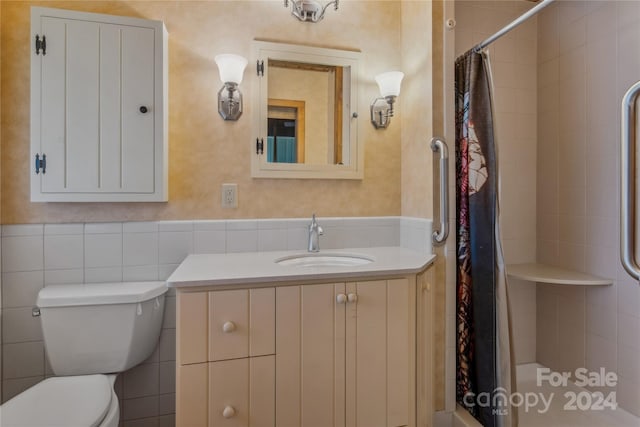 bathroom featuring vanity, toilet, walk in shower, and tile walls