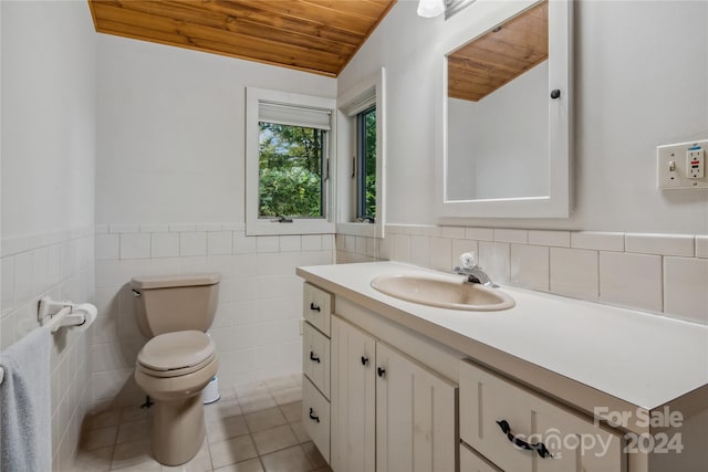 bathroom with tile patterned floors, wood ceiling, toilet, tile walls, and vanity