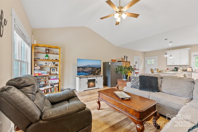 living room with vaulted ceiling, light hardwood / wood-style flooring, ceiling fan, and a healthy amount of sunlight