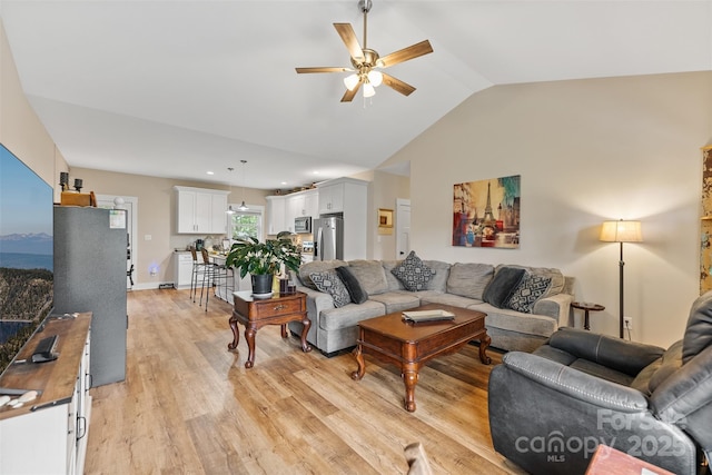 living room with ceiling fan, light hardwood / wood-style flooring, and lofted ceiling