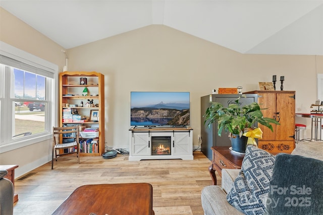 living room with light wood-type flooring and lofted ceiling