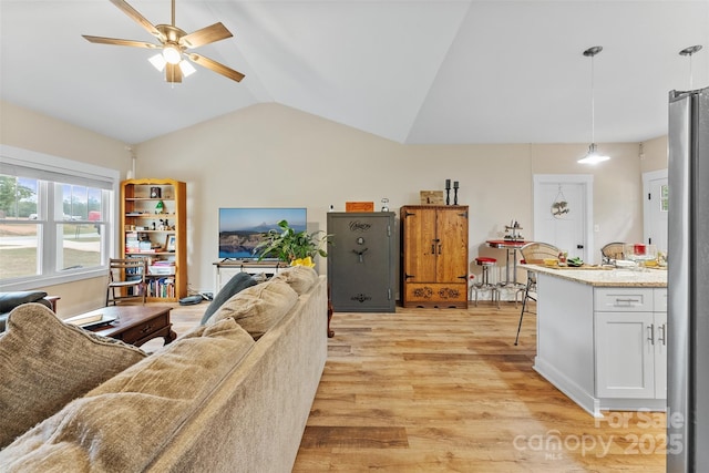 living room featuring light wood-type flooring, ceiling fan, and lofted ceiling