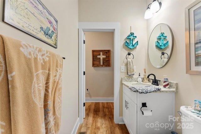 bathroom with vanity, hardwood / wood-style flooring, and toilet