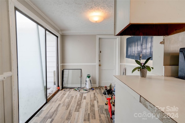 interior space featuring a textured ceiling, light hardwood / wood-style flooring, and wood walls