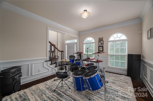 game room featuring a wainscoted wall, ornamental molding, and dark wood-style flooring