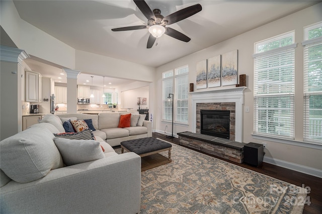 living room featuring a fireplace, a ceiling fan, dark wood-style flooring, and baseboards