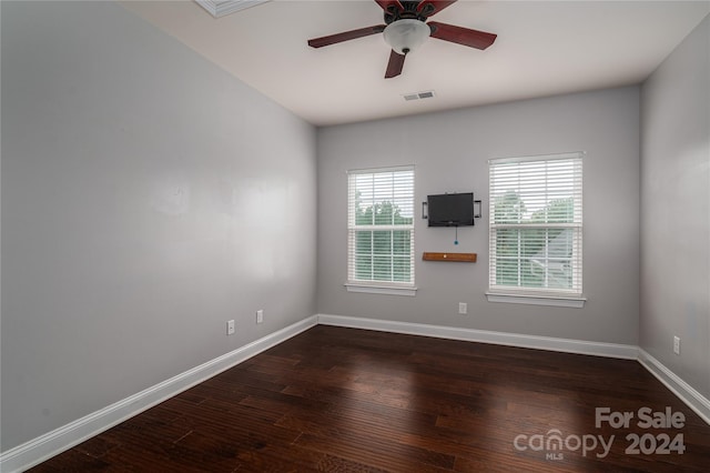 spare room with visible vents, ceiling fan, baseboards, and wood finished floors