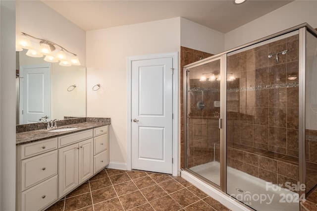 full bath with vanity, a shower stall, and tile patterned flooring