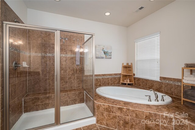 bathroom with tile patterned flooring and shower with separate bathtub