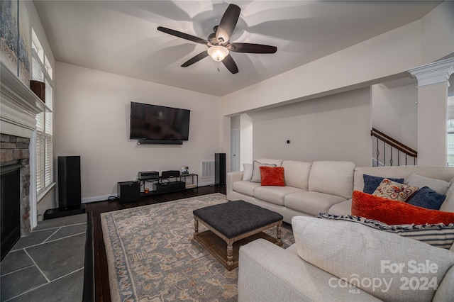 living room featuring visible vents, baseboards, ceiling fan, stairway, and a fireplace