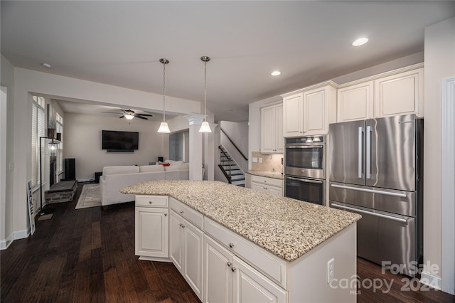 kitchen with a kitchen island, dark wood-type flooring, ceiling fan, appliances with stainless steel finishes, and white cabinets