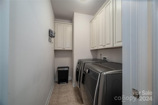 clothes washing area featuring cabinet space, independent washer and dryer, and baseboards