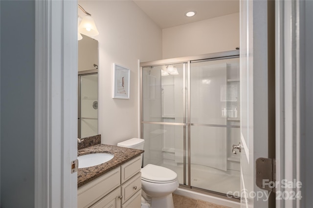 bathroom with a shower stall, toilet, and vanity
