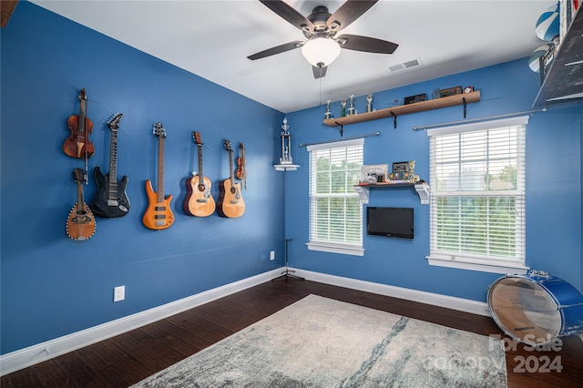 interior space with ceiling fan, wood finished floors, visible vents, and baseboards