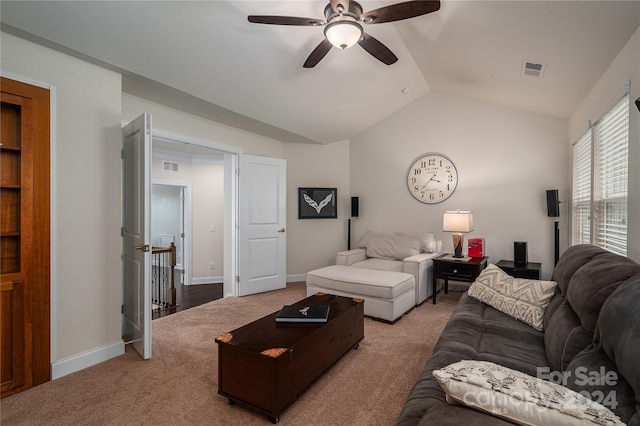carpeted living area with visible vents, baseboards, ceiling fan, and vaulted ceiling