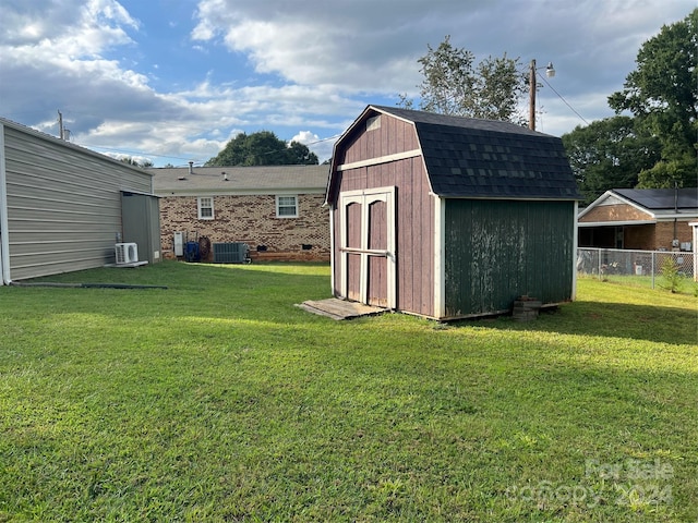 exterior space with fence, ac unit, cooling unit, an outdoor structure, and a storage unit