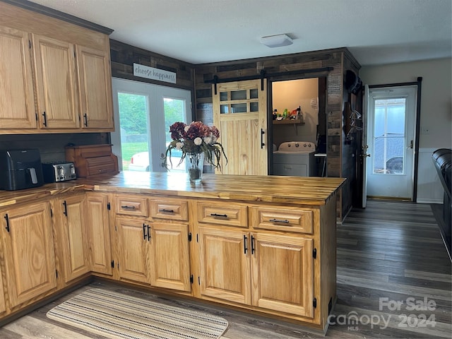 kitchen with washer / clothes dryer, a barn door, and wood finished floors