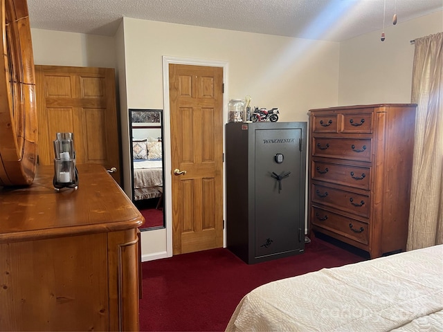 bedroom with a textured ceiling and dark carpet