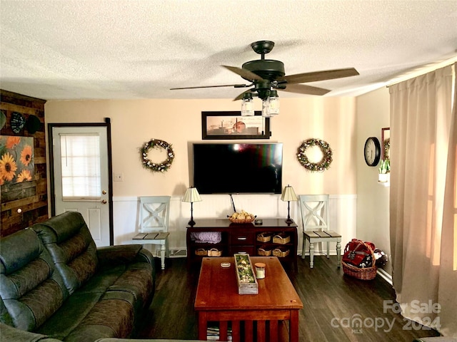 living area featuring a textured ceiling, a ceiling fan, and wood finished floors