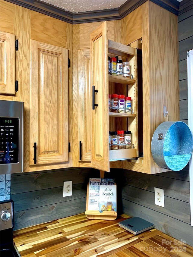 room details featuring stainless steel microwave and wooden walls