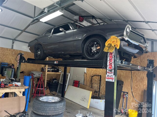 garage featuring a workshop area, wooden walls, and a garage door opener