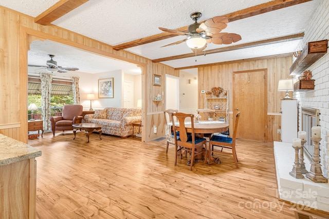 dining space featuring beam ceiling, a textured ceiling, and ceiling fan