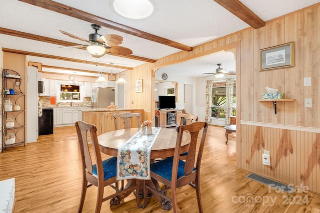 dining room with wood walls and ceiling fan