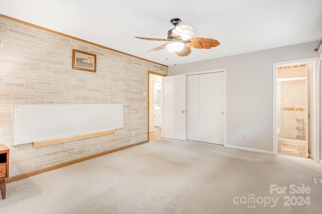 unfurnished bedroom featuring ensuite bathroom, ceiling fan, light colored carpet, and a closet