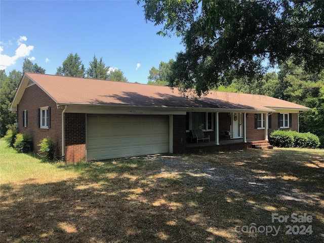 ranch-style home with a garage and covered porch