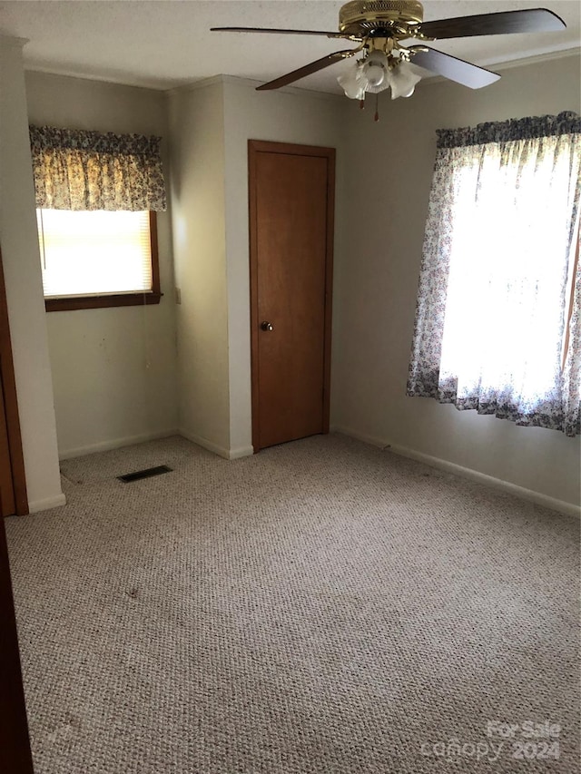 carpeted spare room with ceiling fan