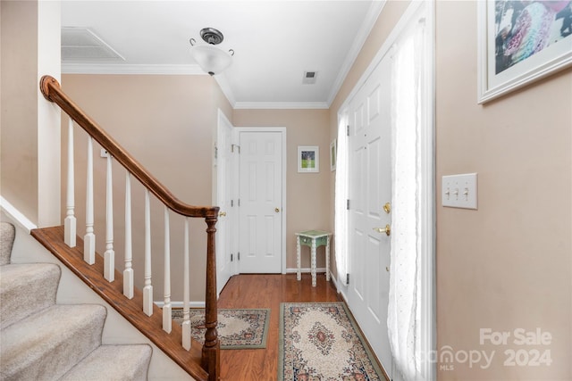 foyer entrance featuring hardwood / wood-style floors and crown molding