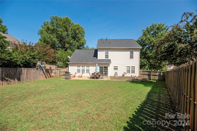 back of property with a yard and a patio