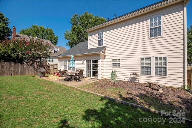 rear view of property with a lawn and a patio