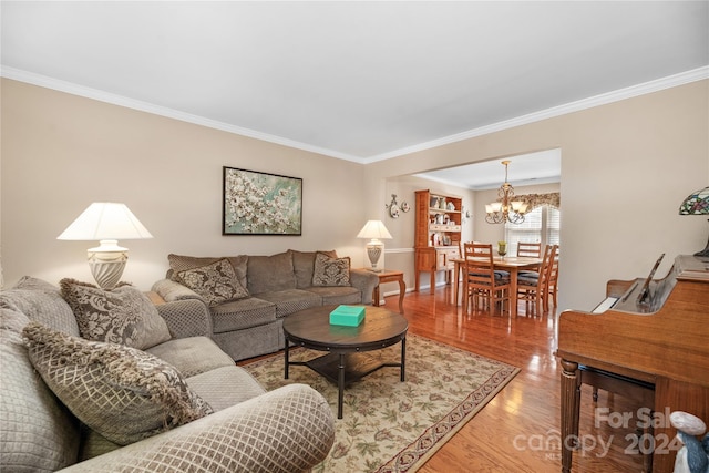 living room featuring crown molding, a notable chandelier, and hardwood / wood-style floors