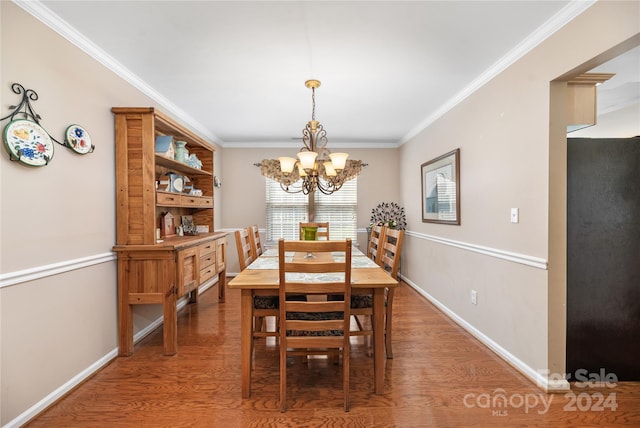 dining room featuring crown molding, a chandelier, and dark hardwood / wood-style flooring