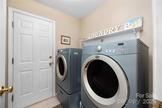 washroom with separate washer and dryer and light tile patterned floors