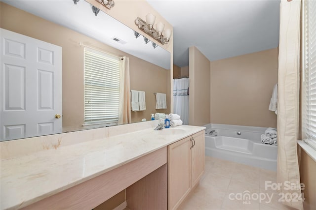 bathroom featuring tile patterned flooring, a bathing tub, and vanity