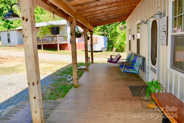 wooden terrace featuring a lawn