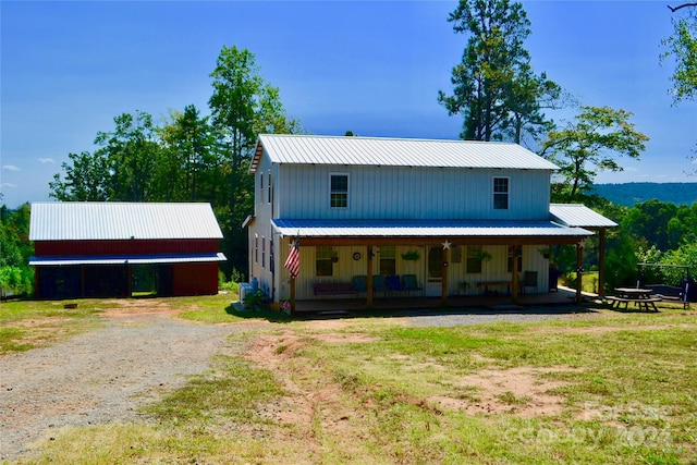 back of house featuring a yard and covered porch