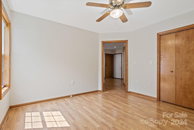 unfurnished bedroom featuring a closet, light hardwood / wood-style floors, and ceiling fan