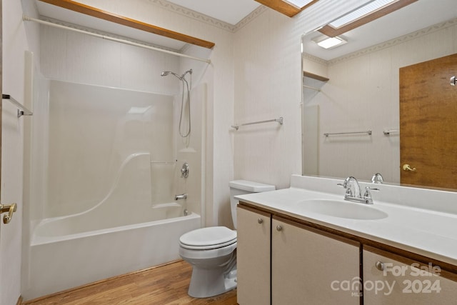 full bathroom with wood-type flooring, washtub / shower combination, vanity, and toilet