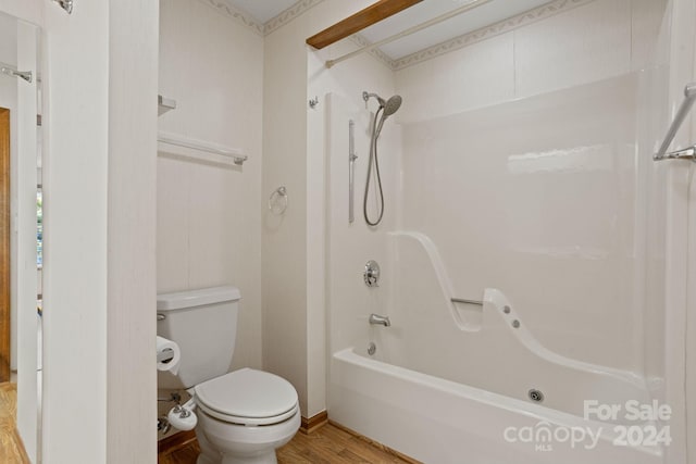 bathroom with hardwood / wood-style floors, toilet, and bathtub / shower combination