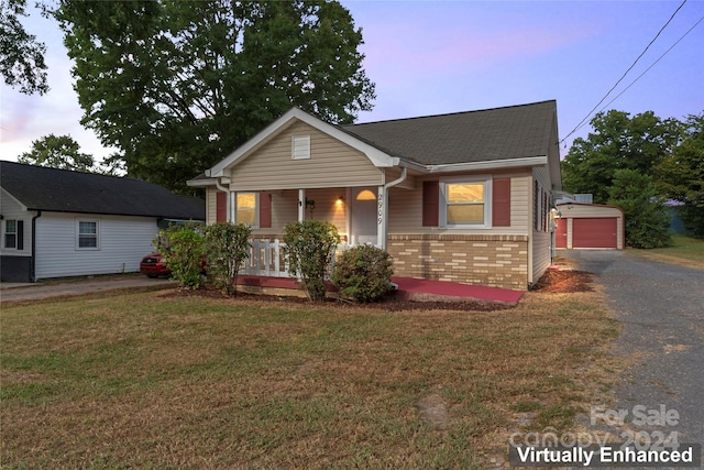 view of front of house featuring a yard, covered porch, and a garage