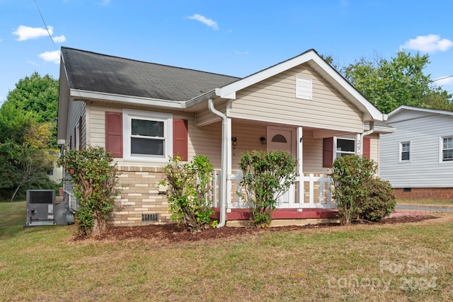 view of front of property featuring a front yard, a porch, and central air condition unit