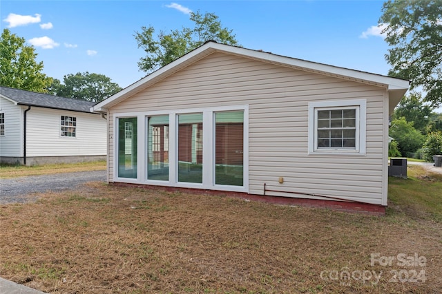 back of house featuring a lawn and central AC