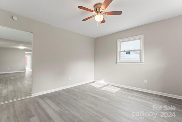 spare room featuring light wood-type flooring, a healthy amount of sunlight, and ceiling fan